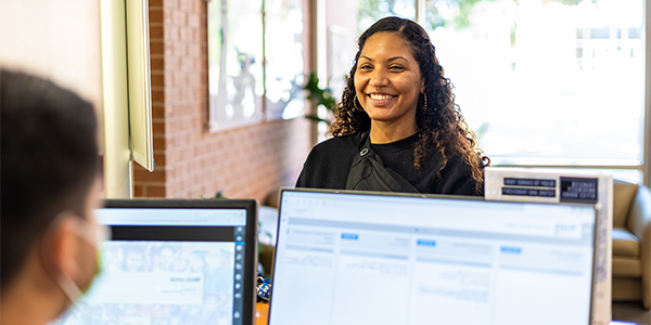 woman smiling at person working on computer